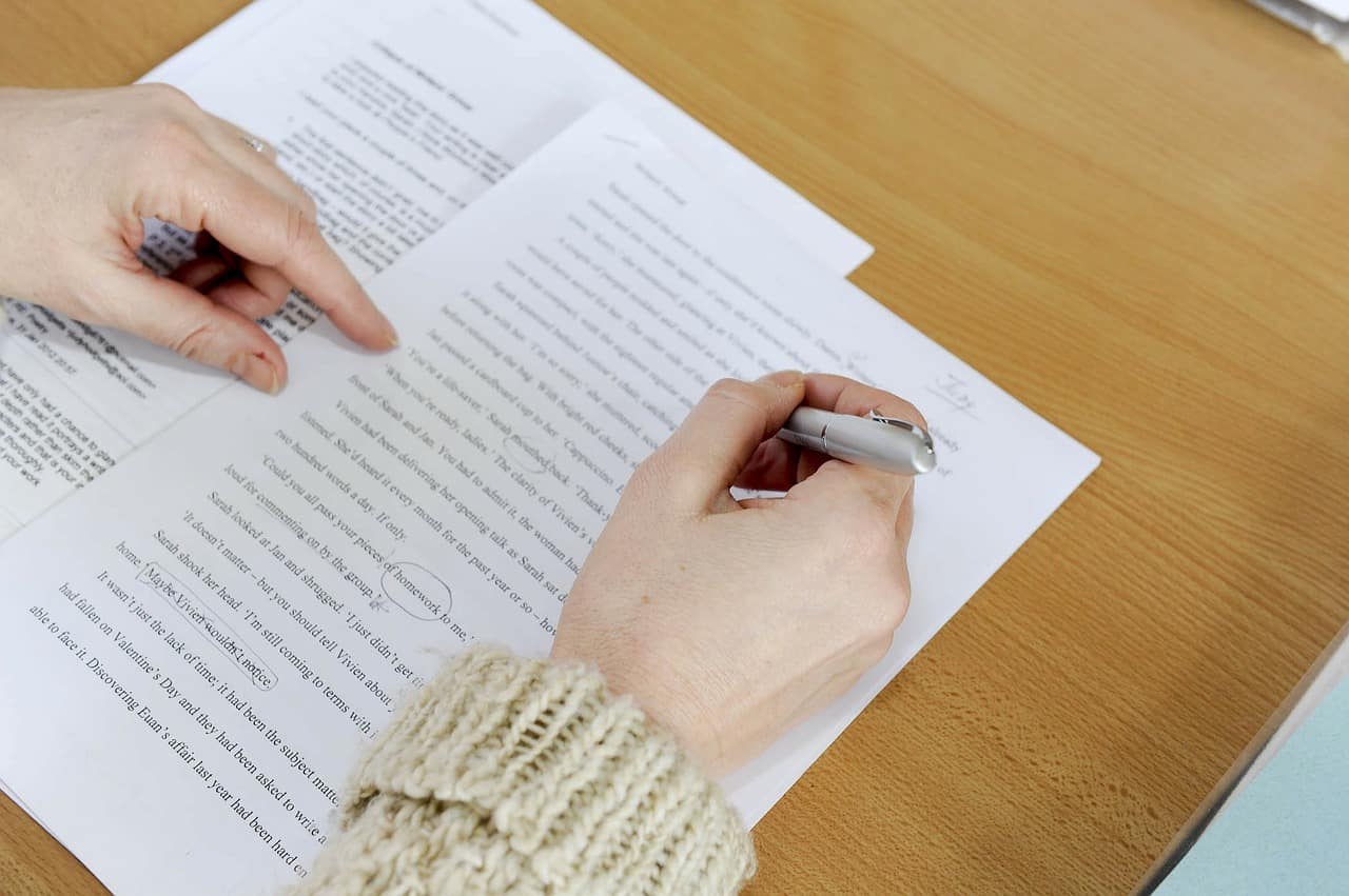 An image of a person writing on a piece of paper